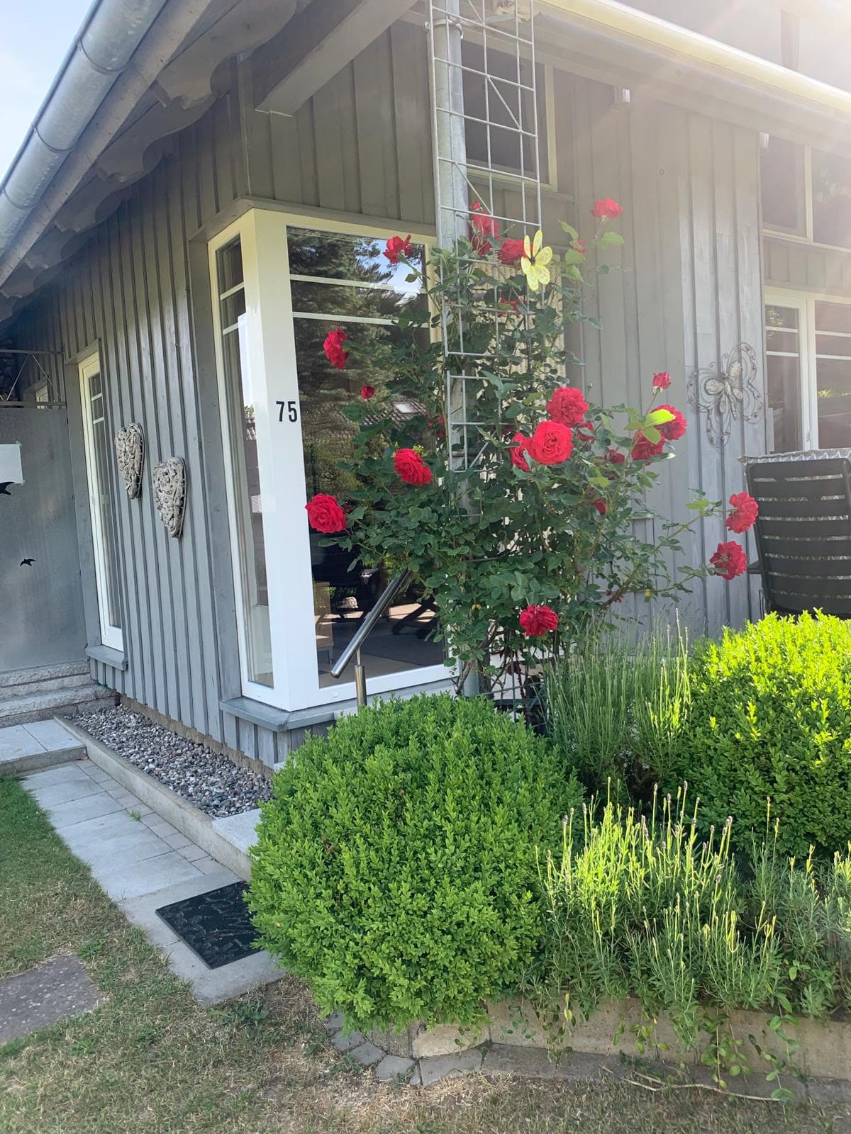 Hauseingang mit Kletterrosen und der Hausnummer 75