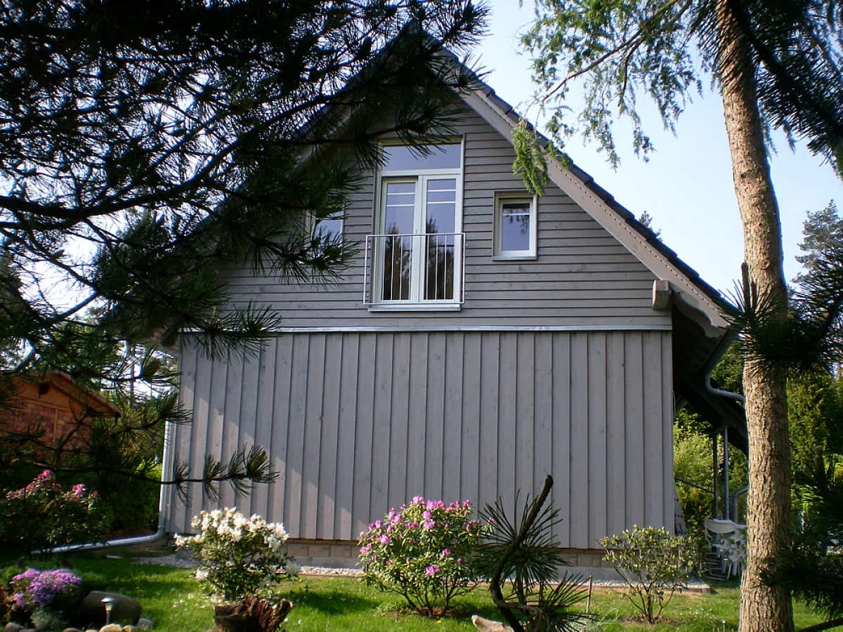Nordseite des Ferienhauses mit Garten und blühenden Rhododendren