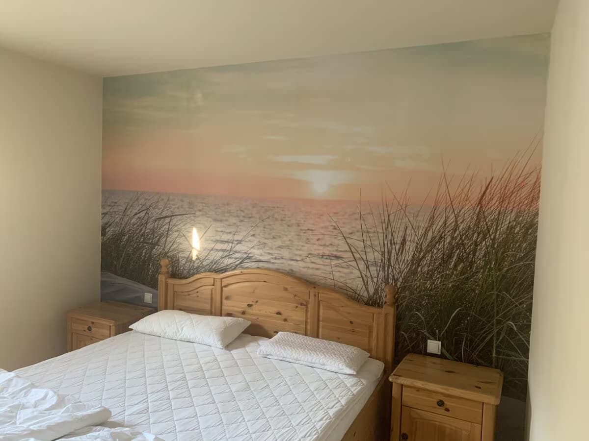 Schlafzimmer im Erdgeschoss mit Doppelbett und Strand-Fototapete
