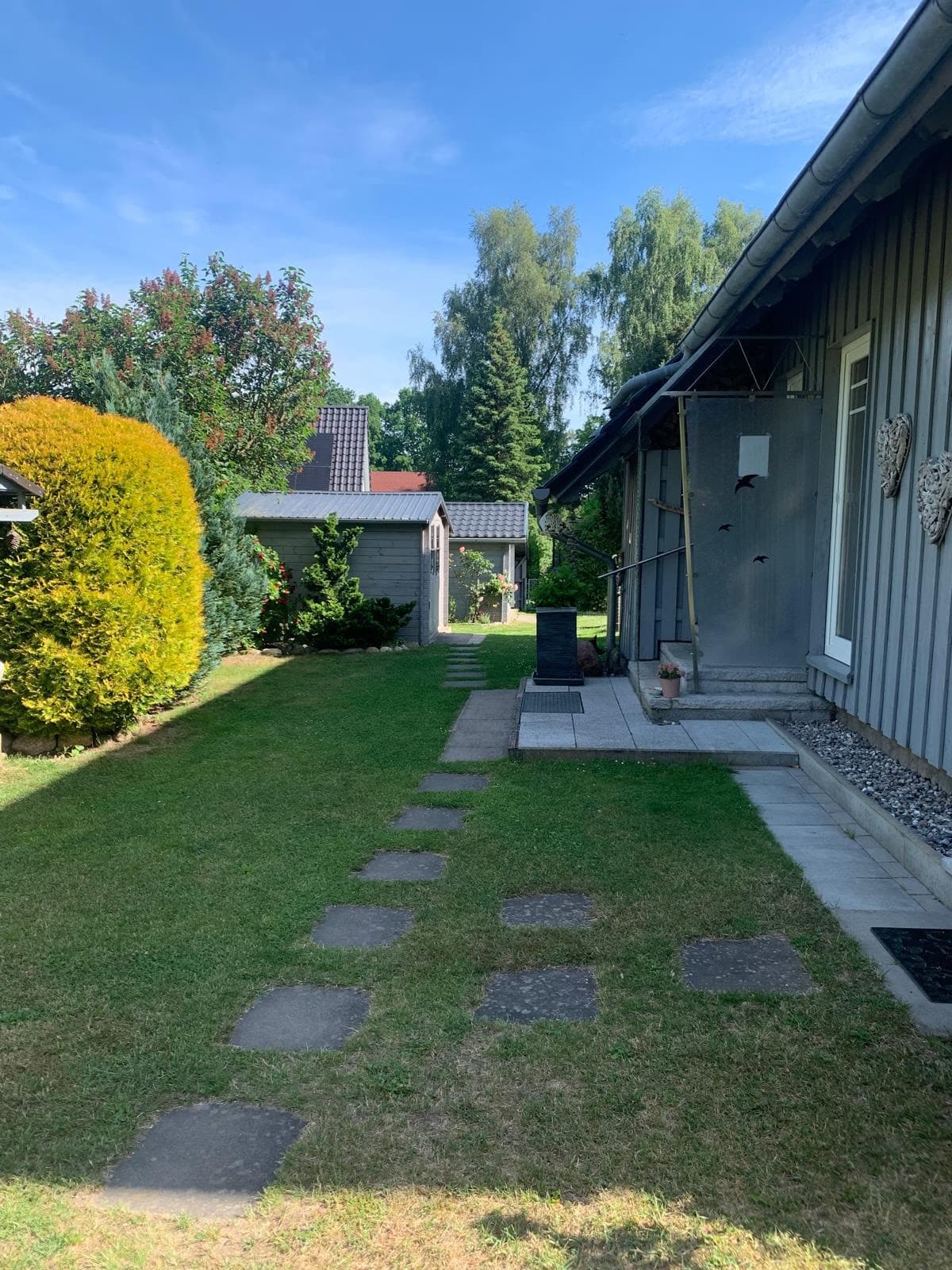 Trittsteinpfad durch den Rasen zur Terrasse