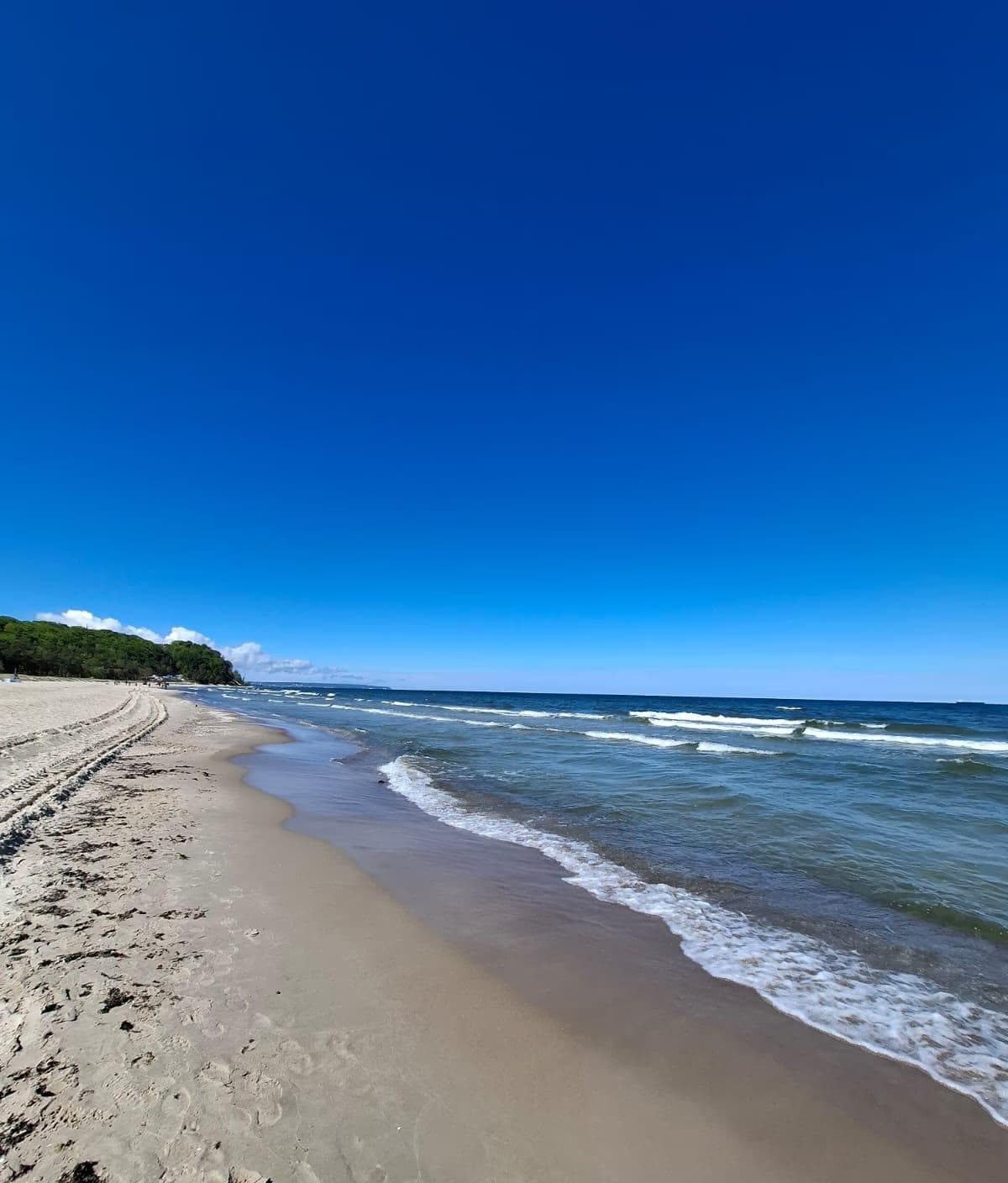 Feiner Sandstrand von Binz unter tiefblauem Himmel